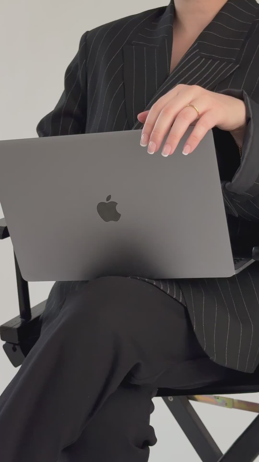 Business woman with laptop sat in directors chair drinking coffee